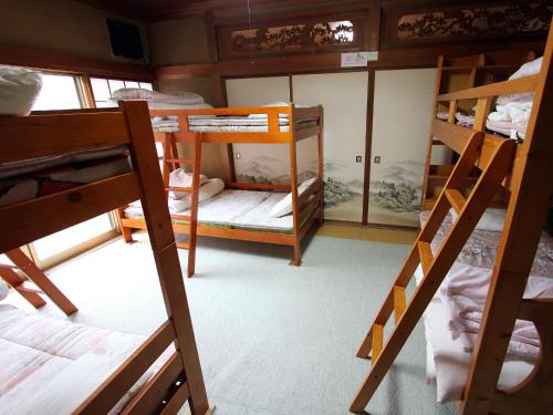 a room with several bunk beds in a house at Towadako Backpackers in Towada