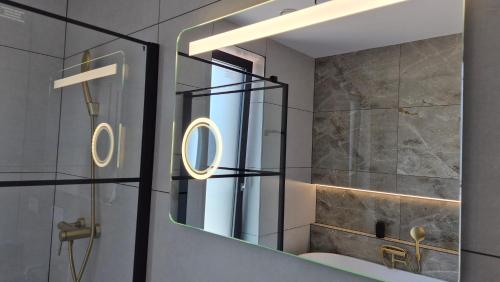 a bathroom with a mirror and a sink at Apartman Bartimej 3A in Bobrów