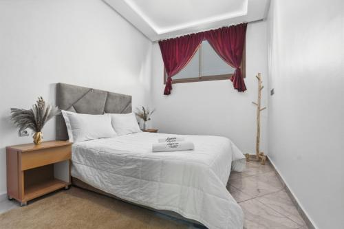 a bedroom with a white bed with a window at White Majorelle Casa Grande in Tamraght Ouzdar