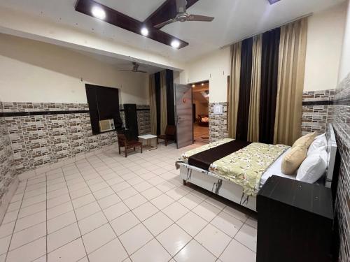 a bedroom with a bed and a tv in it at Hotel CHINTPURNI JMC in Bharwain