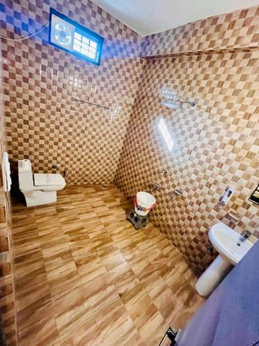 a bathroom with a toilet and a sink and a shower at Hotel CHINTPURNI JMC in Bharwain