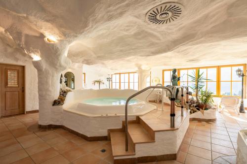 a large bathroom with a bath tub in a room at Hotel Glocknerhof in Berg im Drautal
