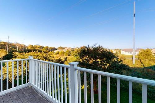 a white railing on a porch with a view of a yard at Bear Trap Dunes - 126B October Glory Ave in Ocean View