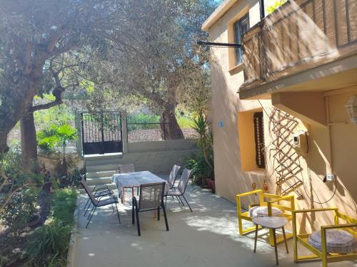 a patio with a table and chairs next to a building at Petrohori before midnight in Pylos