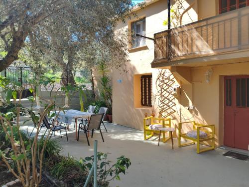a patio with a table and chairs and a building at Petrohori before midnight in Pylos