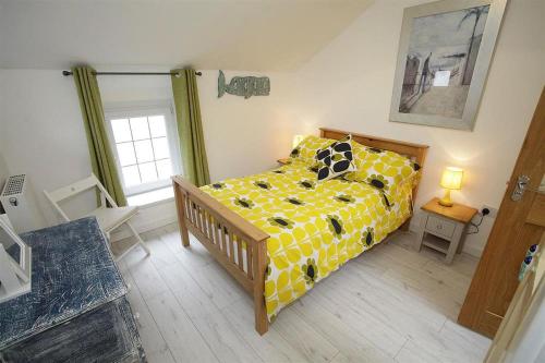 a bedroom with a bed with a yellow comforter at 1 Bed in Mumbles oc-hh1210 in The Mumbles