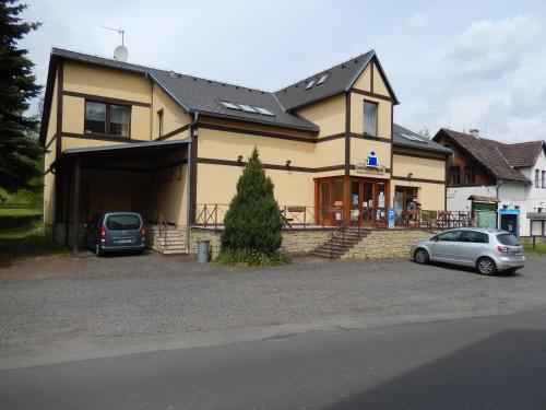 a house with two cars parked in front of it at Penzion v Infocentru in Srbská Kamenice