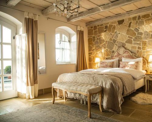 a bedroom with a large bed and a stone wall at Maison Bagatell Badacsony in Badacsonytomaj
