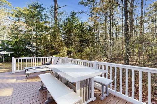 a wooden deck with a picnic table and benches at Middlesex Beach - 9 Bridge in Bethany Beach