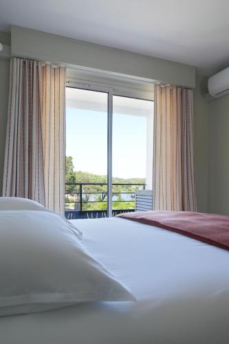 a bedroom with a bed and a large window at Chiberta Ocean & Golf Suite in Anglet