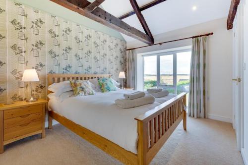 a bedroom with a large bed and a window at High Mill in Beadnell