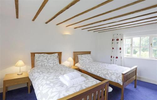 two beds in a room with two lamps and two windows at 5 Bed in Beccles oc-ksf in Wangford