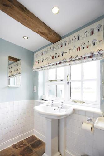 a white bathroom with a sink and a window at 5 Bed in Beccles oc-ksf in Wangford