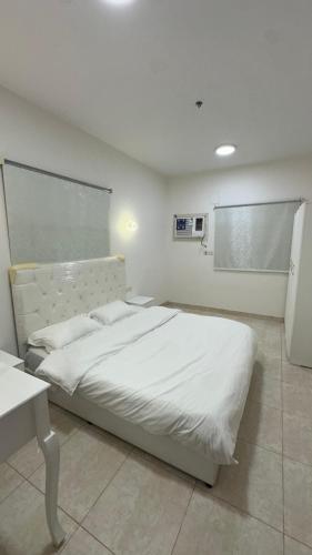 a bedroom with a white bed in a room at شقق ابو طلال المفروشة in Sakakah