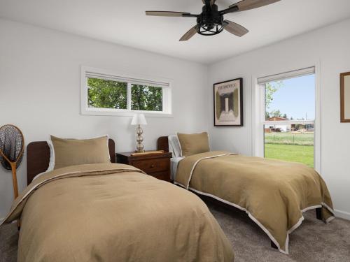 two beds in a bedroom with a ceiling fan at Mountain View Home on 2 Acres in Bozeman