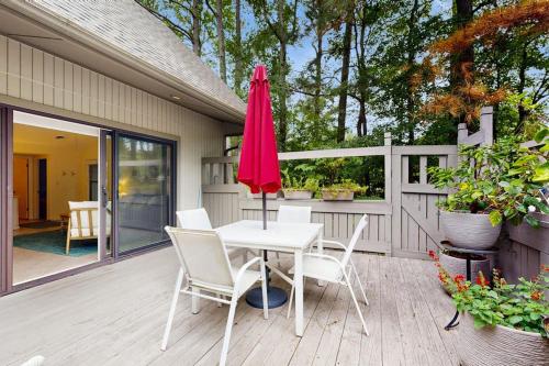 a patio with a white table and chairs and an umbrella at Sea Colony - 7903 Timberlake in Bethany Beach