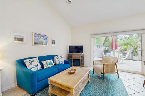 a living room with a blue couch and a table at Sea Colony - 7903 Timberlake in Bethany Beach