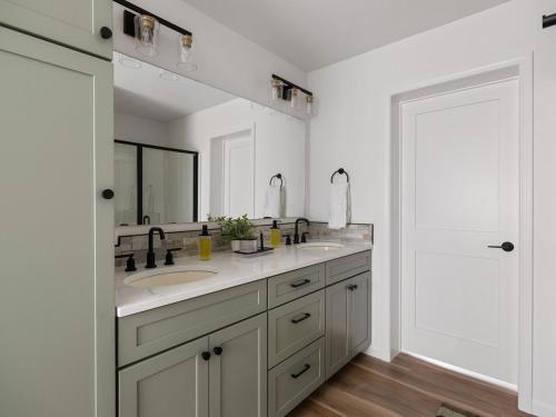 a white bathroom with two sinks and a mirror at Mountain View Home on 2 Acres in Bozeman