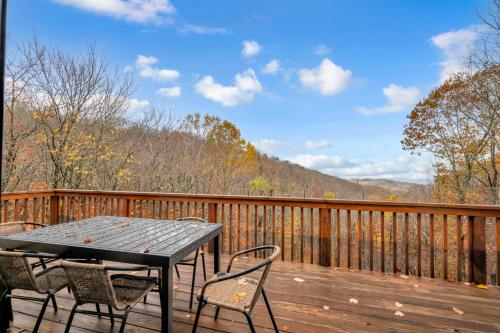 a wooden deck with a table and chairs on it at Heavens Door in Beech Mountain