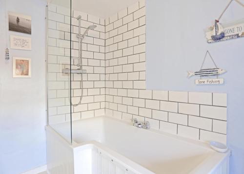 a white bathroom with a tub and a shower at 1 Bed in Southwold oc-aapebb in Southwold