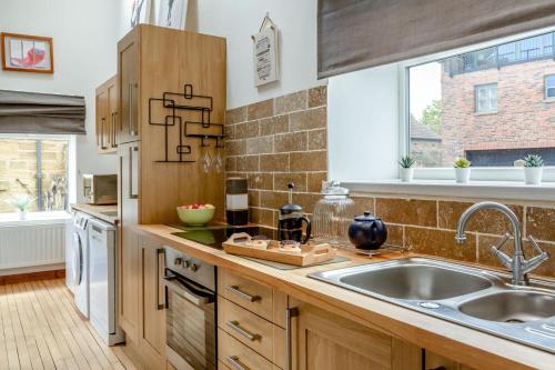 a kitchen with wooden cabinets and a sink at Boca Chica Cottage in Cambois