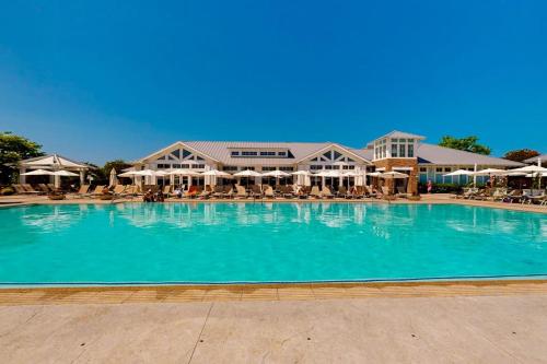 a large swimming pool with chairs and umbrellas at The Peninsula --- 33129 Serenity Circle #87 in Millsboro
