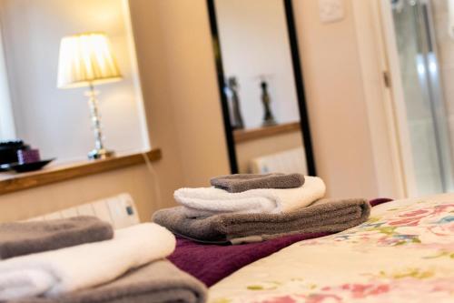 a pile of towels sitting on top of a bed at Becws Clyd in Trawsfynydd