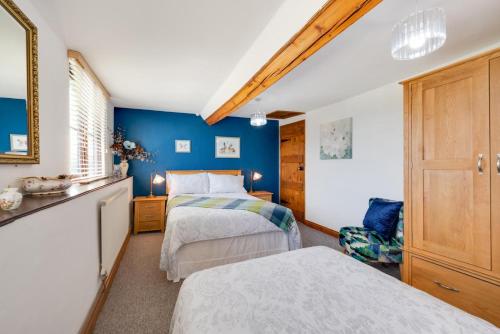 two beds in a bedroom with blue walls at 3 Bed in Llanidloes oc-waa246 in Llangurig