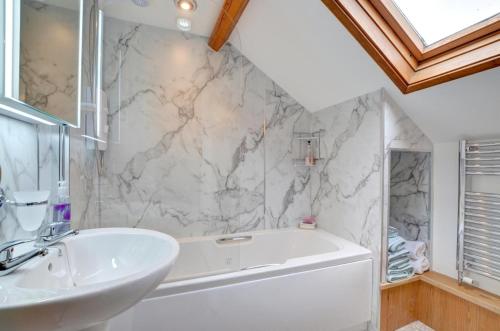 a bathroom with a white tub and a sink at 3 Bed in Llanidloes oc-waa246 in Llangurig