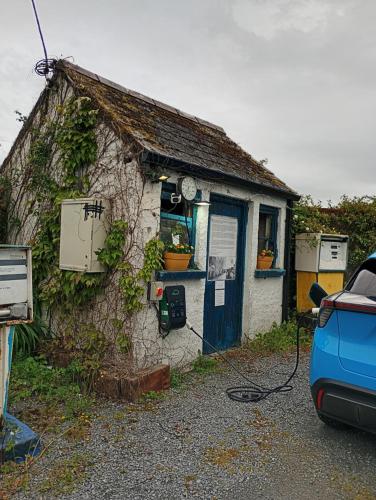 a small house with a blue door and a car parked outside at Matty's Pub - Apartment's in Carlow