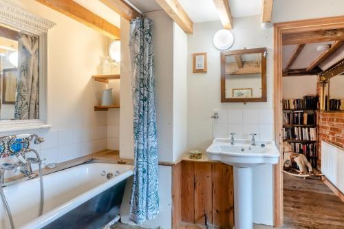 a bathroom with a tub and a sink at 4 Bed in Reepham oc-497 in Reepham