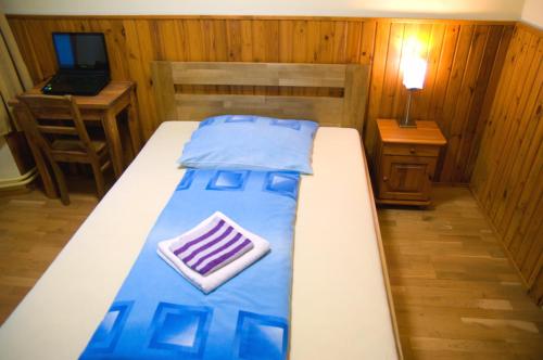 a bedroom with a bed and a desk with a laptop at Penzión Pod bránou in Poprad