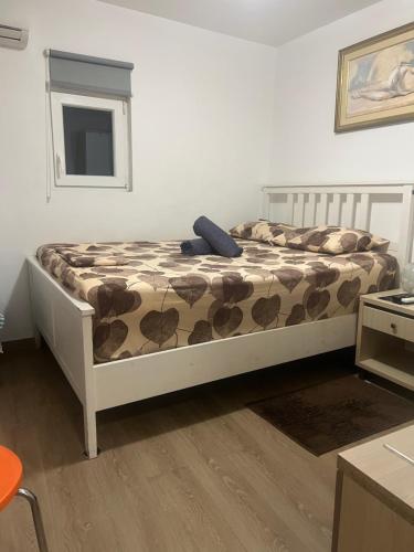 a bedroom with a bed with a blanket on it at Private Rooms with a Beautiful Veranda in Heraklio