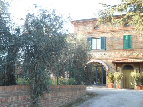 a brick building with a tree in front of it at Orto degli Ulivi in Sinalunga