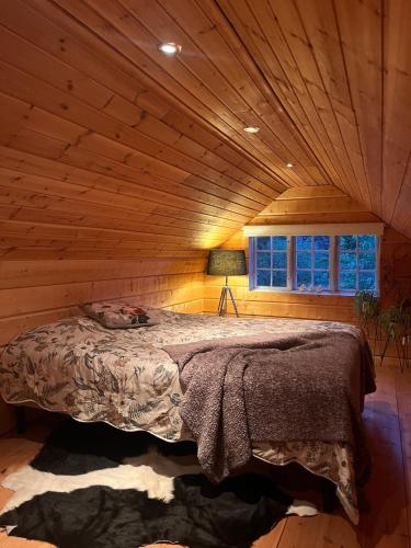 a bedroom with a bed in a log cabin at Gästhus med båtplats in Kvicksund