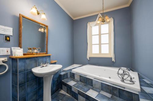 a blue bathroom with a tub and a sink at Auberge la Romance in La Malbaie