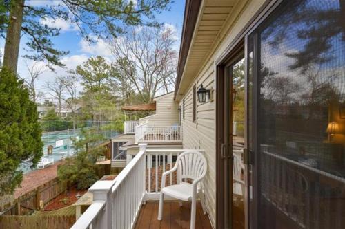 a porch with a white chair on a house at Bethany Pines -- 412 Bethany Drive in Bethany Beach