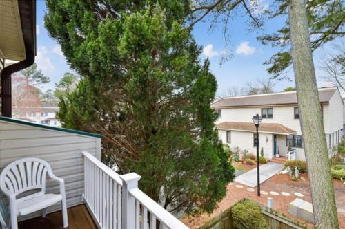 a porch with a white chair and a house at Bethany Pines -- 412 Bethany Drive in Bethany Beach