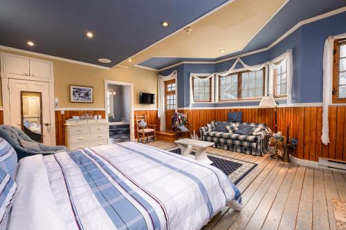 a bedroom with a large bed and a living room at Auberge la Romance in La Malbaie
