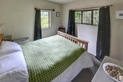 a bedroom with a bed with a green blanket on it at 1 Bed in Llanrwst oc-wag232 in Llanrwst