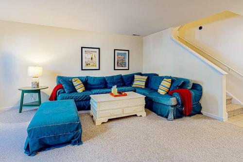 a living room with a blue couch and a table at Sea Colony --- 56200 Pine Cone Ln in Bethany Beach