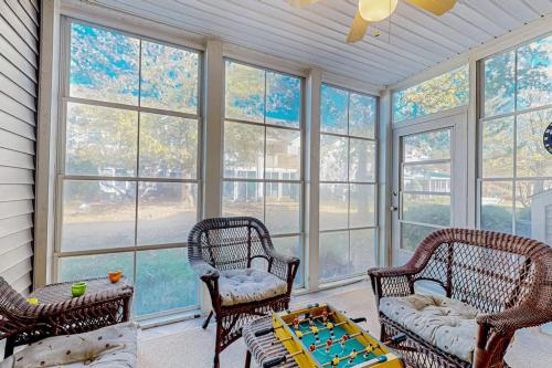 a living room with chairs and a table and windows at Sea Colony --- 56200 Pine Cone Ln in Bethany Beach