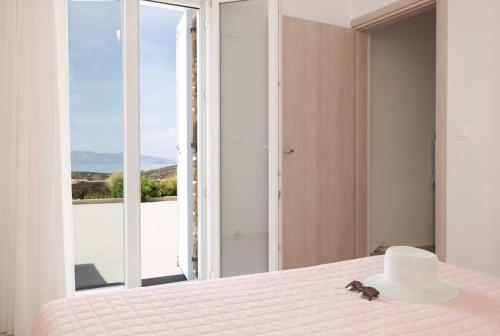 a bedroom with a bed with a hat and a window at Paradissi Marmara in Cherronisos