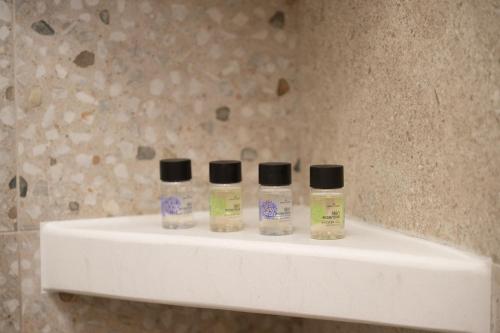 three bottles of liquids sitting on a shelf in a bathroom at Paradissi Marmara in Cherronisos