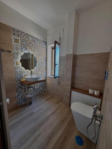 a bathroom with a white toilet and a sink at Tramonto di Calabria in Pizzo