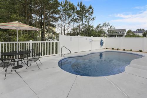 a pool with a table and chairs and an umbrella at 39609 Waterworks Ct in Bethany Beach