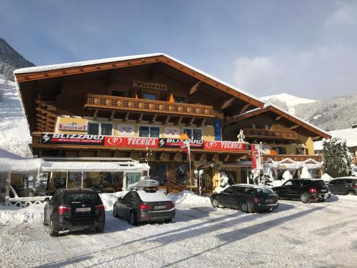 a ski lodge with cars parked in the snow at Hotel Victoria in Maishofen