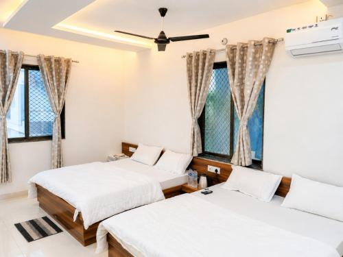 two beds in a room with windows at Hotel Virat Palace 600 From Khatu Shyam Ji in Khātu