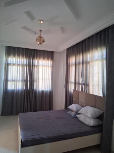 a bedroom with a large bed with curtains and a window at Ksour tataouine in Qaşr al Muqābilah