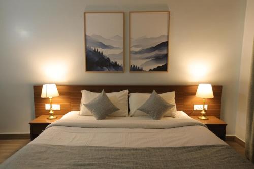 a bedroom with a large bed with two lamps at Two Seas Residence - Boutique Residences in Ooty